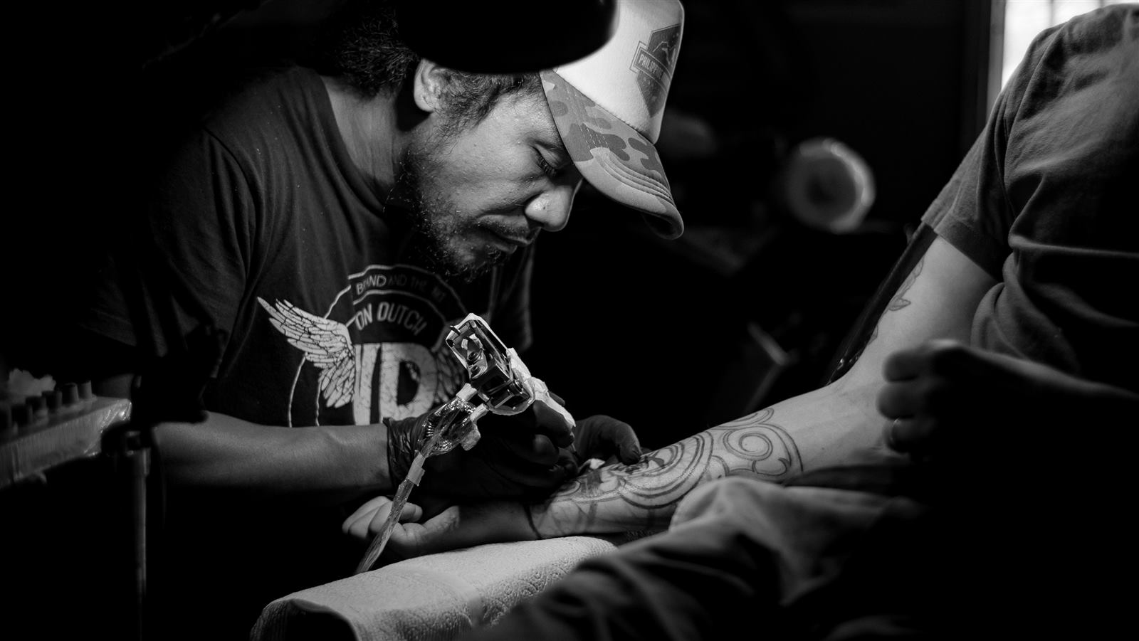 Artista trabalhando em uma tatuagem